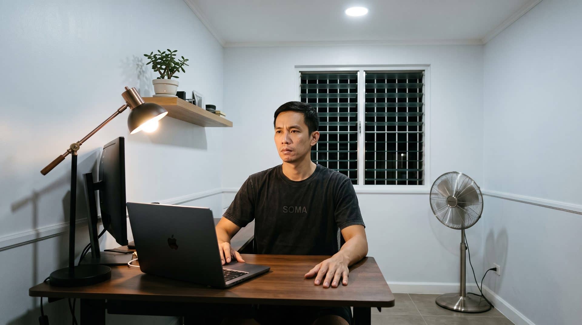 A Filipino man with both hands flat on table surface in modest dining area in Manila.